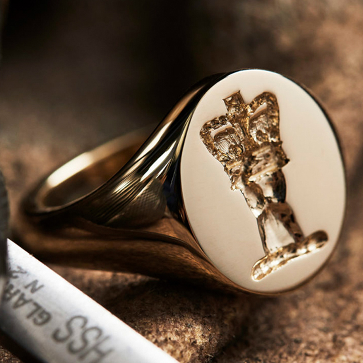 Rebus gold oval signet ring with crest