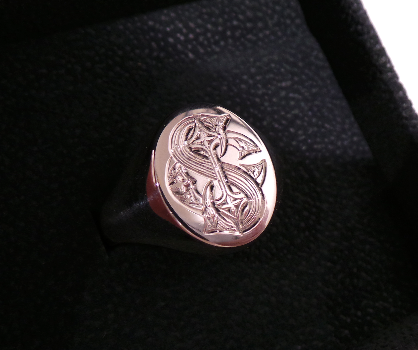 Signet ring bearing engraved monogram in black velvet ring box